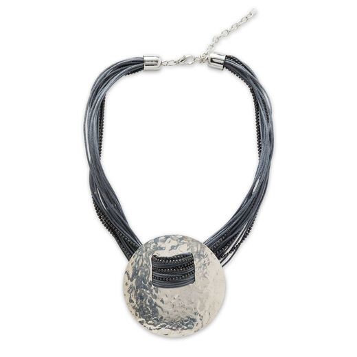 A necklace featuring a cord with multiple strands and a large silver hammered disc pendant.